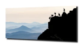 obraz na szkle Alpinista szczyt góry